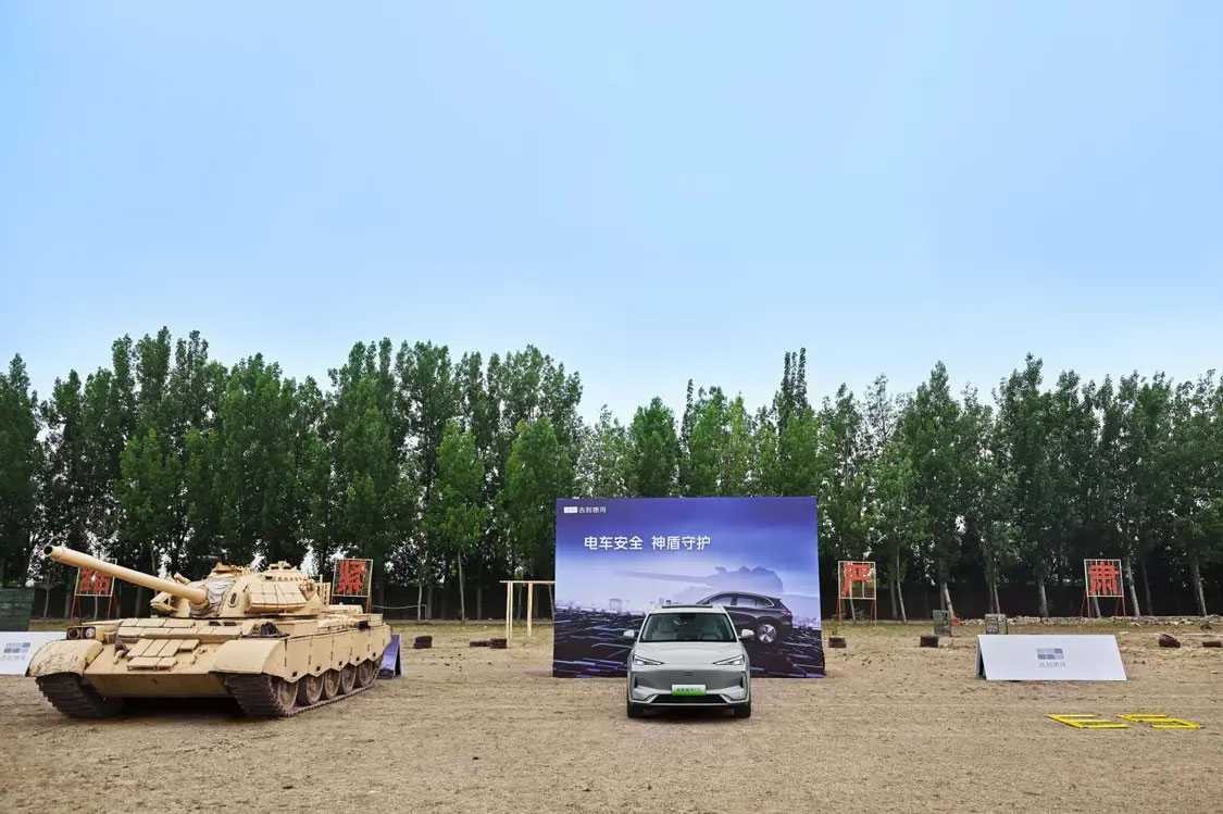 SUV électrique Geely Galaxy E5 stationné à côté d’un char de combat ZTZ-59D pour test extrême de sécurité batterie