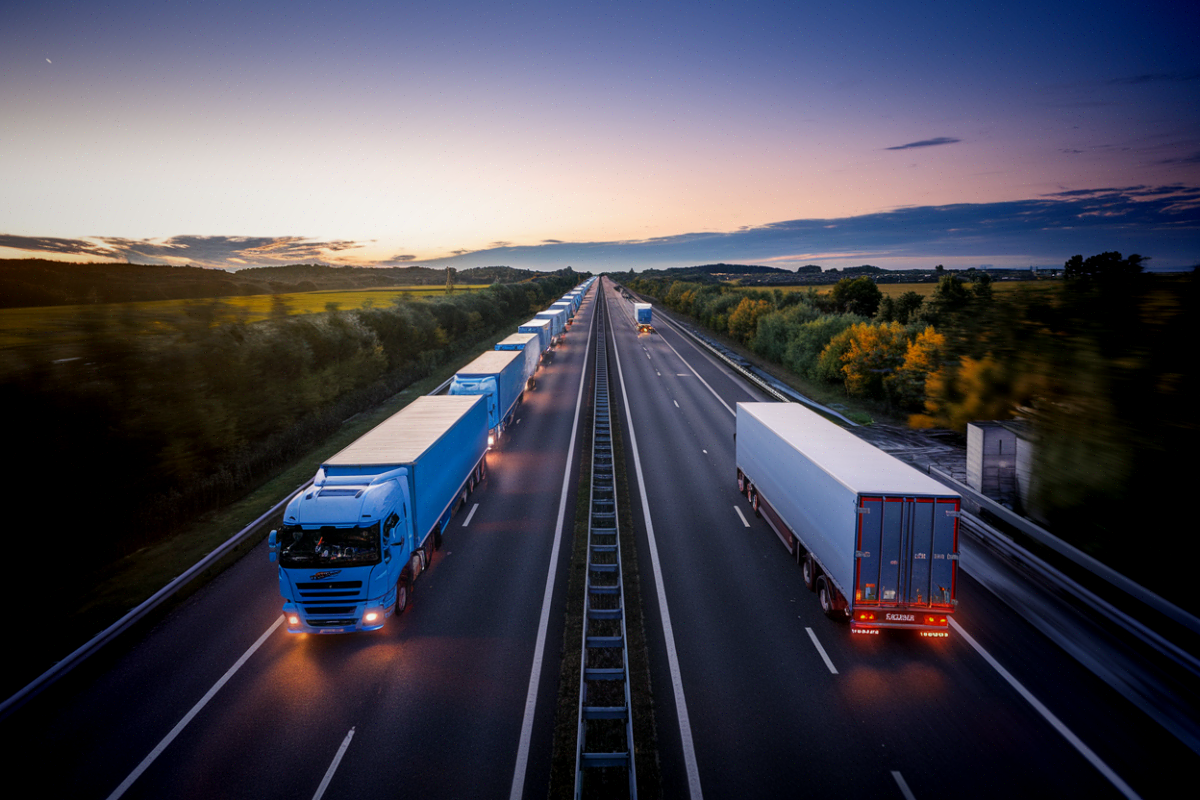 Une file de camions de fret au diesel sur une autoroute française au crépuscule illustrant le transport de marchandises